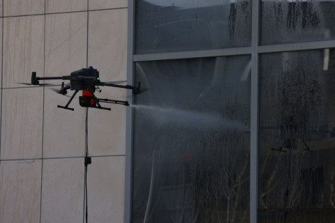 Барилгын гадна фасад, гэрлэн дохиог тусгай төхөөрөмж ашиглан угааж байна