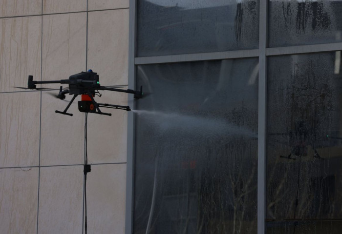 Барилгын гадна фасад, гэрлэн дохиог тусгай төхөөрөмж ашиглан угааж байна